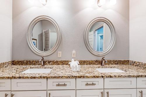 a bathroom with two sinks and two mirrors at Miramar Beach Villas Building 6 Unit B in Destin