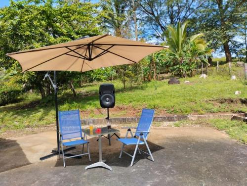 twee stoelen en een paraplu met een luidspreker bij House in Cuajiniquil ,Belen de nosarita in Cuajiniquil
