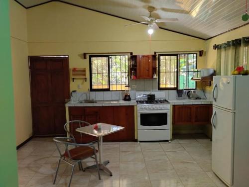 een keuken met een tafel en een witte koelkast bij House in Cuajiniquil ,Belen de nosarita in Cuajiniquil