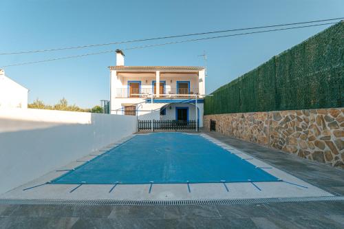 a swimming pool in front of a house at Casa Mirador de los Tomillos in Azuel