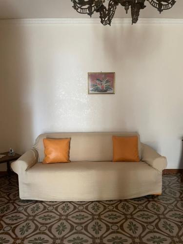 a couch with two orange pillows in a living room at ANNABELL'S in Cassibile
