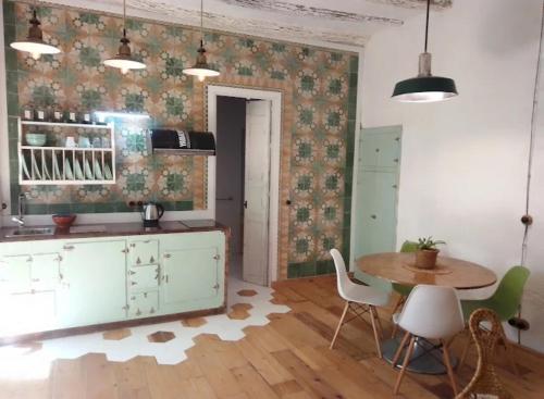 a kitchen with a table and a table and chairs at La gota de leche 1 in Sanlúcar de Barrameda