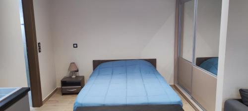 a small bedroom with a blue bed and a mirror at Superior Seaview Apartment in Antirrio