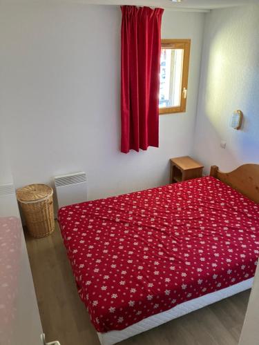 une chambre avec un lit avec une couverture rouge dans l'établissement Le balcon d'Orcières, à Orcières