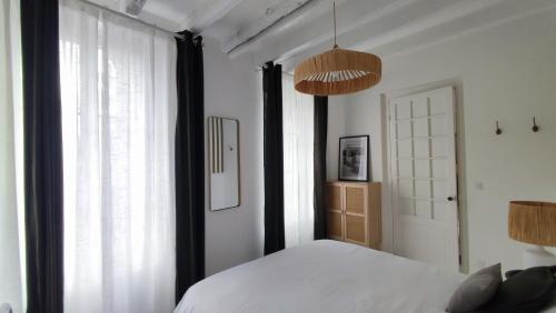 a bedroom with a bed and a large window at Maison Charmeilles - Le studio Canon de Fronsac in Fronsac