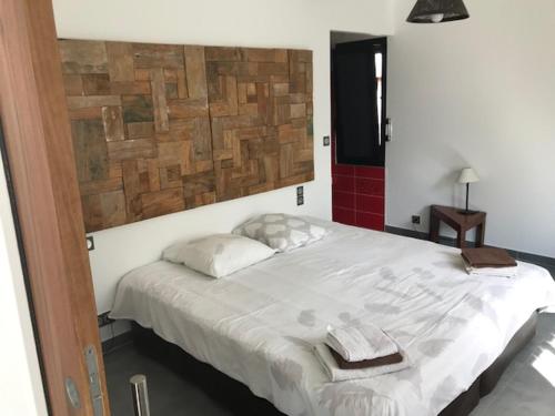 um quarto com uma cama grande e toalhas em Gîte Noir Lapin em Lesquin