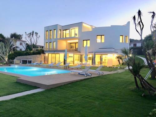 una grande casa con una piscina di fronte di Fenandgi Luxury Hospitality at its finest ! a Porto Columbu - Perdʼe Sali