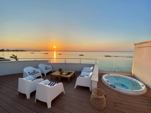 una terrazza con vasca idromassaggio, sedie e tavolo di Fenandgi Luxury Hospitality at its finest ! a Porto Columbu - Perdʼe Sali