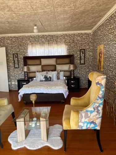 Un dormitorio con una cama, una silla y una mesa. en P&l exclusive beauty parlour, en Johannesburgo