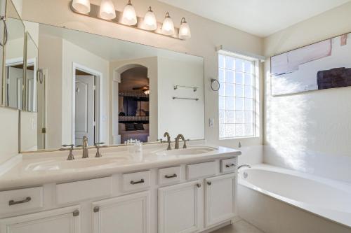 ein weißes Badezimmer mit einer Badewanne, einem Waschbecken und einer Badewanne in der Unterkunft Spacious Scottsdale Home with Private Heated Pool in Scottsdale