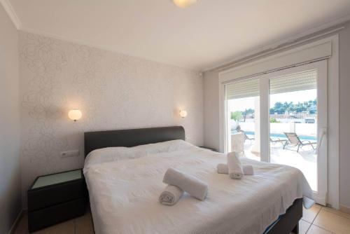 a bedroom with a bed with two towels on it at Villa Malibu - PlusHolidays in Moraira