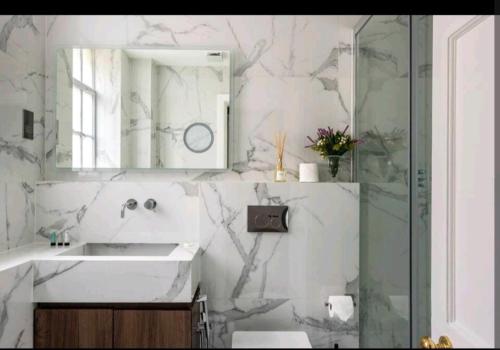 y baño con lavabo, espejo y ducha. en Luxury 4 Bed Knights Bridge, en Londres