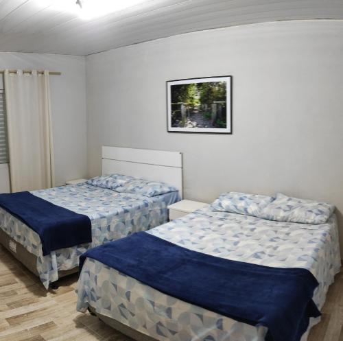 1 dormitorio con 2 camas y una foto en la pared en Residencial Praia da Daniela, en Florianópolis