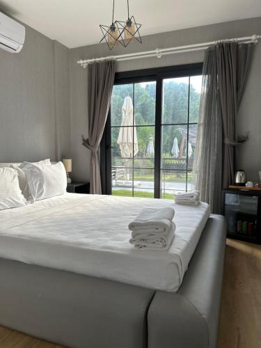 Malta Hotel Bodrum في بودروم: غرفة نوم بسرير كبير عليها مناشف