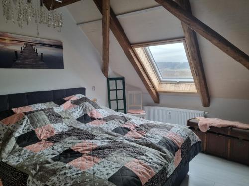 ein Schlafzimmer mit einem Bett mit einer Decke darauf in der Unterkunft Ferienwohnung Haus Madlen in Kirschau