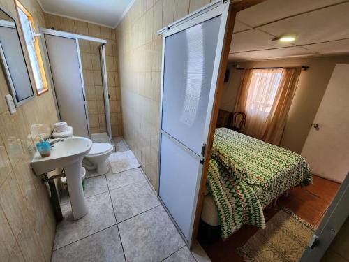 een badkamer met een douche, een toilet en een wastafel bij HOSTAL SOL ATACAMA -CALDERA in Caldera