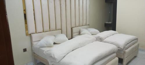 Duas almofadas brancas sentadas numa cama num quarto em Executive Residency em Multan