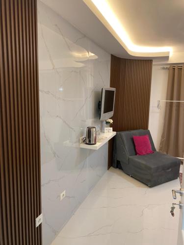 a room with a chair and a tv on a wall at Villa Jelena in Negotino