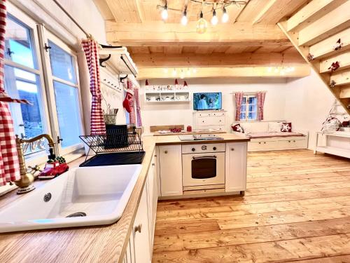 a kitchen with white appliances and wooden floors at Santova roubenka in Štramberk