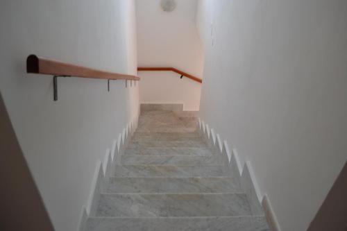 a stairway with white walls and stone stairs at casa vacanze dei navigatori on the sea in Pontecagnano