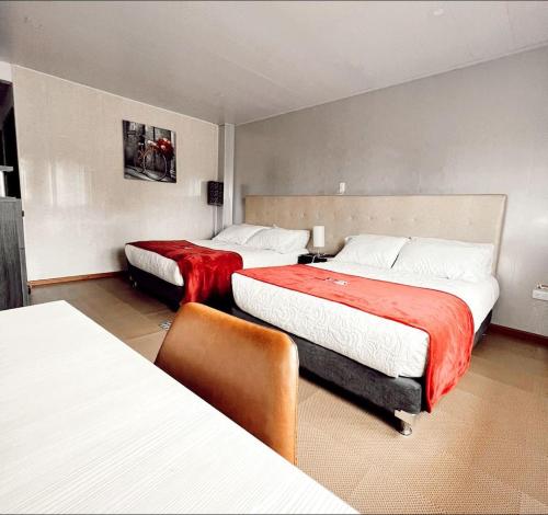 ein Hotelzimmer mit 2 Betten mit roter Bettwäsche in der Unterkunft Hotel Big Day Lago de Tota in Tota