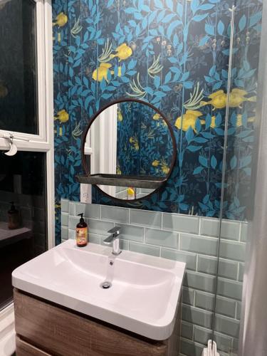 uma casa de banho com um lavatório e um espelho em Staincliff House em Sandown