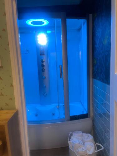 a bathroom with a blue light on a cabinet at Staincliff House in Sandown