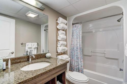 uma casa de banho com um lavatório, um WC e um chuveiro em Oceanfront Condo in Myrtle Beach em Myrtle Beach