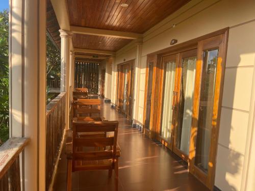 a porch with chairs and tables on a house at Golden Topaz Phu Quoc Resort in Phu Quoc
