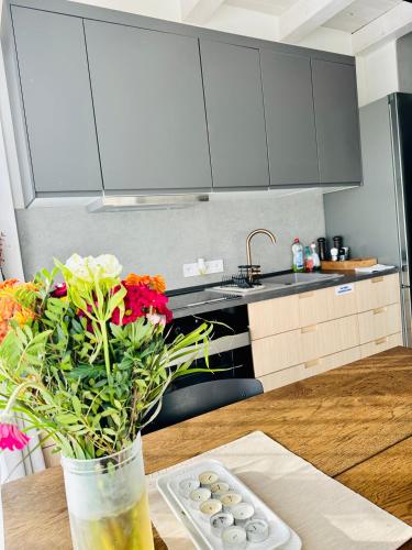 a kitchen with a wooden table with a vase of flowers at STONE Apartment in Žilina