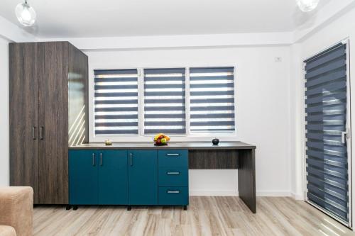 a kitchen with a blue desk in front of a window at Studio modern in Craiova