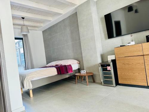 een slaapkamer met een bed en een tafel en een televisie bij STONE Apartment in Žilina