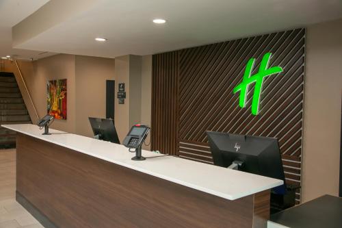a reception desk in a hospital lobby with ataxpayer at Holiday Inn Metairie New Orleans, an IHG Hotel in Metairie