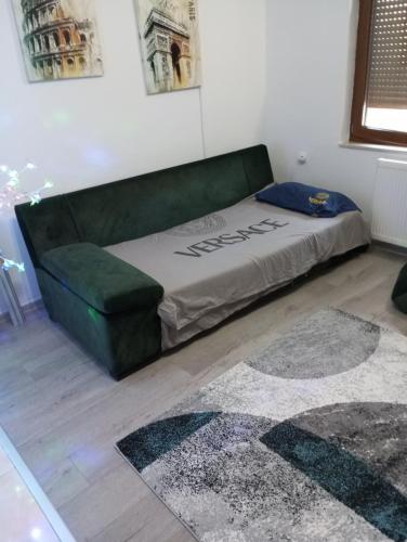 a bed and a green couch in a room at Apartman Old Town in Stolac