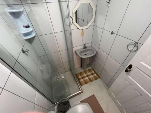 baño pequeño con ducha y lavamanos en Central Praias Suíte 2, en Cabo Frío
