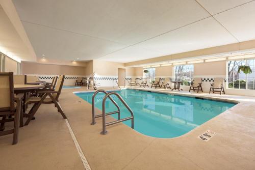 a swimming pool with a pool table and chairs at Country Inn & Suites by Radisson, Clinton, IA in Clinton