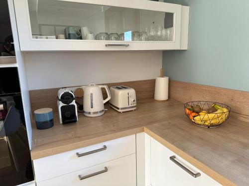 a kitchen with a counter top with a microwave and a bowl of fruit at Sunny House - Villa 4 chambres - Saint Genis Les Ollières in Saint-Genis-les-Ollières