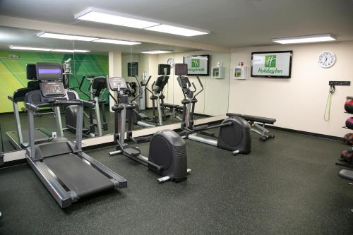 a gym with several tread machines in a room at Holiday Inn Metairie New Orleans by IHG in Metairie