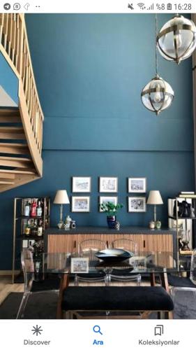 Habitación con pared azul, mesa y sillas. en Virtual hause en Yenimahalle