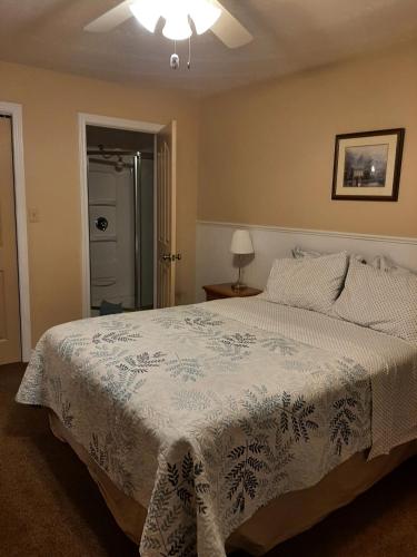 ein Schlafzimmer mit einem Bett mit einer weißen Decke in der Unterkunft Trillium Bed & Breakfast in Niagara Falls