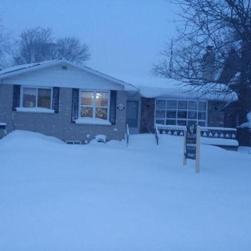 ein Haus mit Schnee auf dem Boden und einem Fenster in der Unterkunft Trillium Bed & Breakfast in Niagara Falls