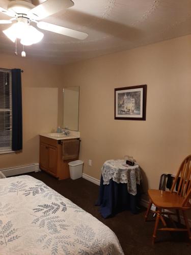 1 dormitorio con 1 cama, lavamanos y mesa en Trillium Bed & Breakfast, en Niagara Falls