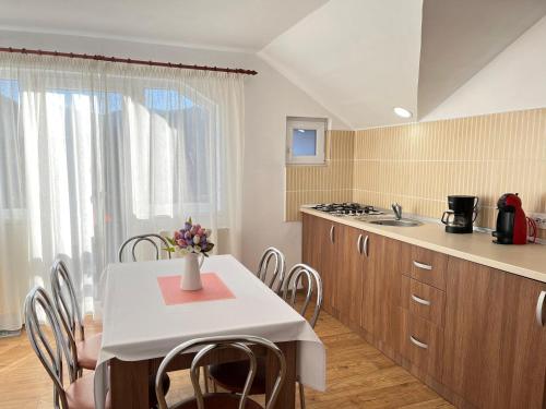 - une cuisine et une salle à manger avec une table et des chaises dans l'établissement Vila Anto, à Şimon