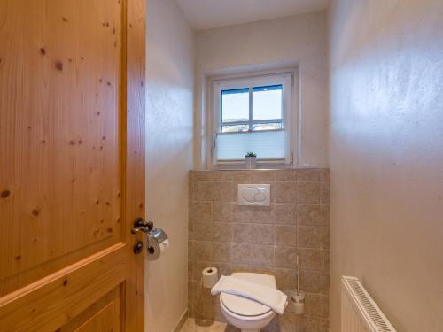 a bathroom with a toilet and a window at Alpen Glück Hotel Villa Lisa garni in Kirchberg in Tirol