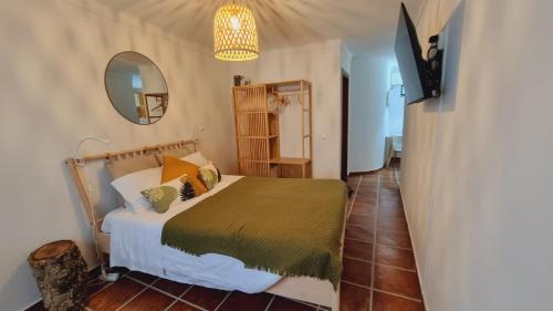 1 dormitorio con cama y espejo en Cantinho da Vila by Portus Alacer, en Alter do Chão