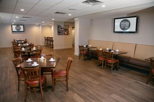 a restaurant with tables and chairs and a couch at Holiday Inn Metairie New Orleans, an IHG Hotel in Metairie