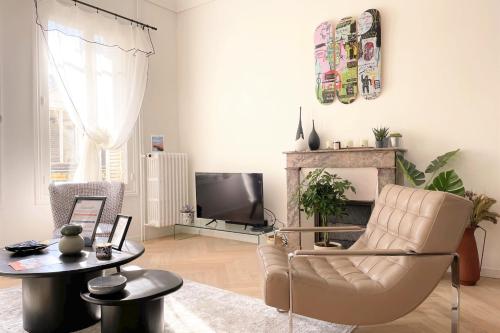 un salon avec une chaise et une télévision dans l'établissement Le Vertigo - Standing - Proche Mairie, à Caen