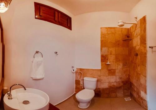 a bathroom with a toilet and a shower and a sink at Pousada Naná in Prea