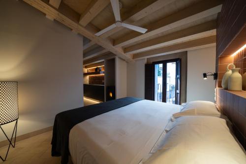 - une chambre avec un grand lit blanc et un plafond dans l'établissement Apartamentos Vilafamés Antic Palau, à Vilafamés