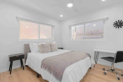- une chambre blanche avec un lit et un bureau dans l'établissement Brand New Ocean-View Beach Home Steps to the Sand!, à Manhattan Beach